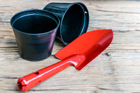 Garden tools shovel red with black planting pots on the old woodenの写真素材