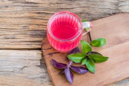 river spiderwort juice in a glass and river spiderwort leaf have medicinal properties on the old wooden tableの写真素材