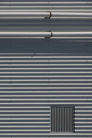 Industrial background of metal wall and pipesの写真素材