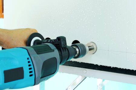 Man hand using his drill in wall