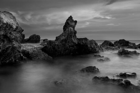 Beautiful sunset at the stone beach in black and whiteの写真素材