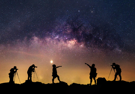 Star-catcher. A person is standing next to the Milky Way galaxy pointing on a star