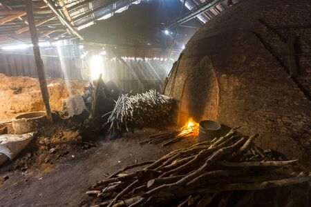Pile of slow burning wood at charcoal factory, Thailandの写真素材