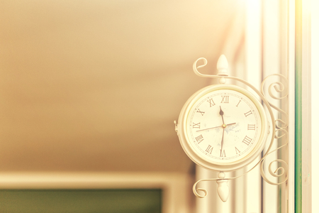 Retro clock hang on the wall with daylightの写真素材