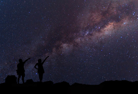 Star-catcher. A person is standing next to the Milky Way galaxyの写真素材