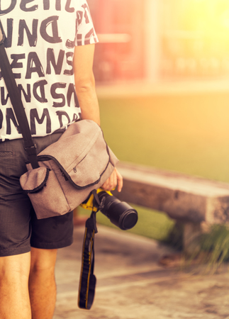 Close up of man holding a camera ready to take a photographの写真素材
