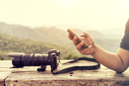 Close up of man using mobile smart phone  with landscape background. Connection using mobile phone.の写真素材