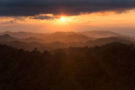 Layer of mountains in the mist at sunset time with burning sky, Nan Province, Thailandの写真素材