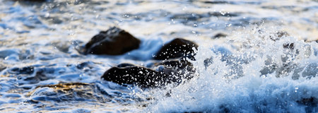 Sea water hits rocks on the beach By the sea with strong wavesの写真素材