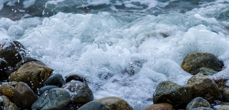 Sea water hits rocks on the beach By the sea with strong wavesの写真素材