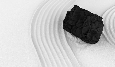 White sand texture with pattern, black stones on fine sand, Japanese ZEN style natural background,...