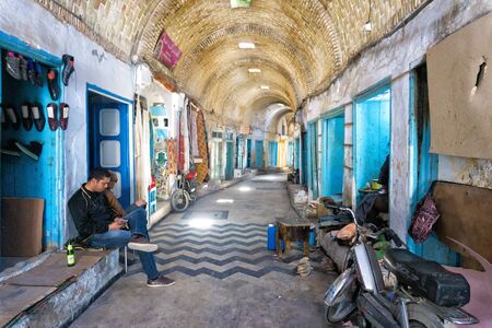 KAIROUAN, TUNISIA - APRIL 9:Men in old alley selling shoes in Kairouan, Tunisia on April 9, 2018.のeditorial素材