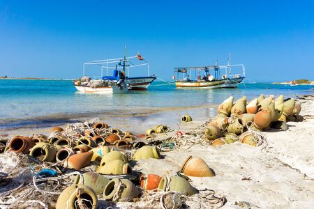 HOUMT SOUK, TUNISIA - APRIL 16: View of boats and fishermen in the beach in the Mediterrenean sea in Djerba,Tunisia on April 16, 2018のeditorial素材