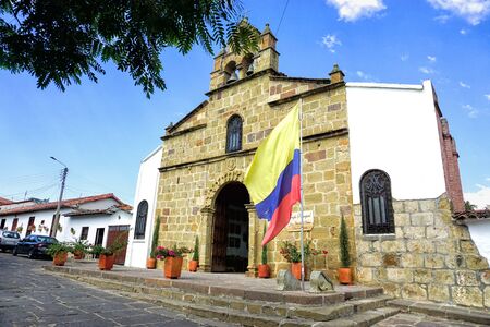 Landscape of the entrance of San Antonio de Padua church and flag in Pinchote, Colombiaの写真素材