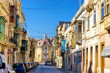 Traditional street with church in the background in Senglea, Maltaの写真素材