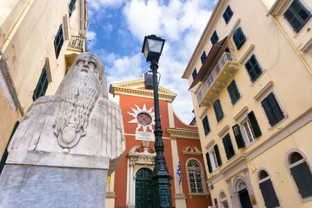 CORFU, GREECE - MAY 21: View of Greek Orthodox priest sculpture in street and old church in Corfu, Greece on May 21, 2018のeditorial素材