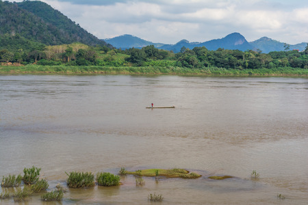 Fishermen on a boat, catching a fish in the river.の写真素材