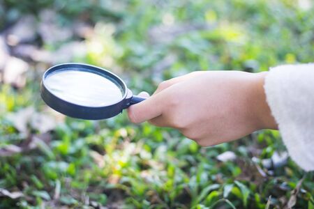 Kids using magnifying glass.