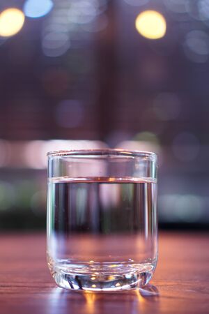 Glass of water on wooden table.