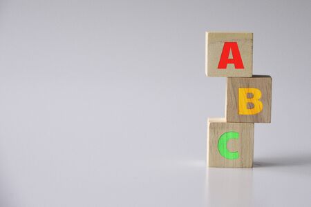 ABC letters alphabet on wooden cube blocks in pillar form on wood tableの写真素材