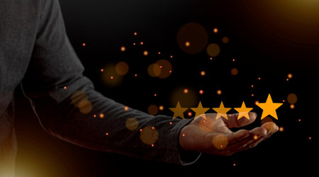 Satisfaction close up on customer man hand pressing on screen with five star rating feedback icon and press level excellent rank for giving best score point to review the service conceptの写真素材