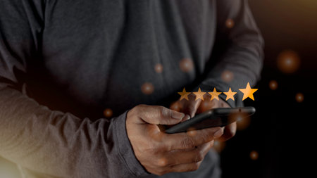 Satisfaction close up on customer man hand pressing on screen with five star rating feedback icon and press level excellent rank for giving best score point to review the service conceptの写真素材