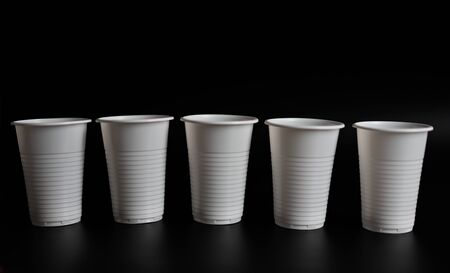 Plastic glasses for drinking on a black background.Plastic glasses for drinking on a black...