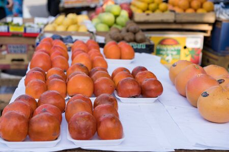 Persimmons on a counter for sale.Persimmons on a counter for sale