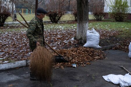 A man cleans and sweeps a yard.A man cleans and sweeps a yardの写真素材