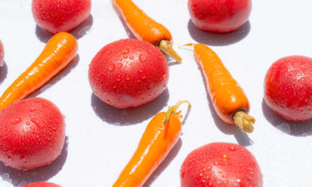 Red tomatoes and carrots on a white background