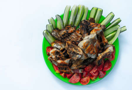 Fried chicken, tomatoes and cucumbers on a white backgroundの写真素材