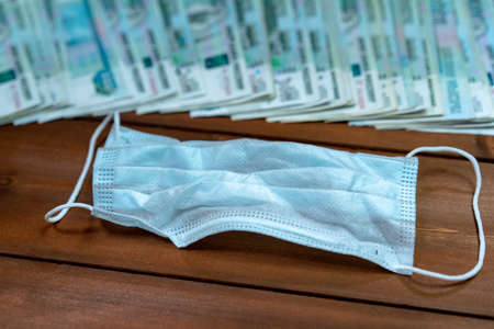 A bundle of money and a protective maskの写真素材