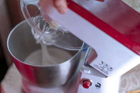 The mixer whips the dough to prepare it for baking.