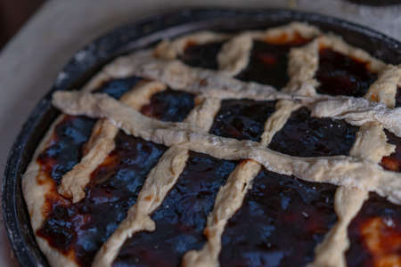 Pie with jam on a baking sheet before baking