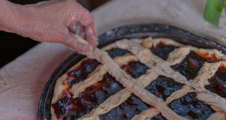 Pie with jam on a baking sheet before bakingの写真素材