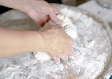 Women's hands knead the dough