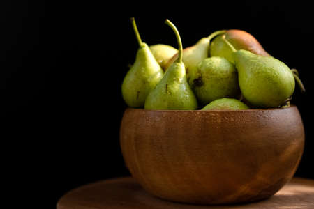 Ripe pear in a wooden dishの写真素材