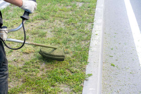 Man mows the grass with a lawn mower