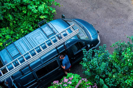 Car with a long ladder on the roofの写真素材