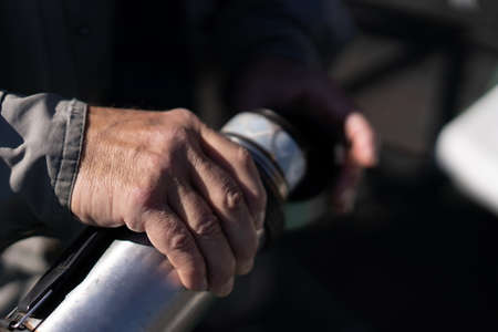 An elderly man pours tea from a flaskの写真素材
