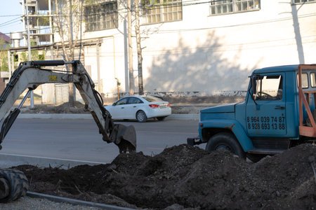 Excavator buries the ground near the road