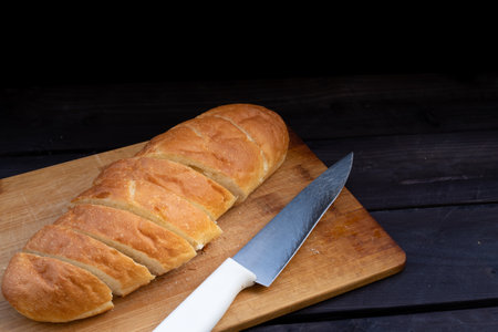Loaf of bread and knife on a boardの写真素材