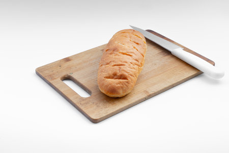 Loaf of bread and knife on a boardの写真素材