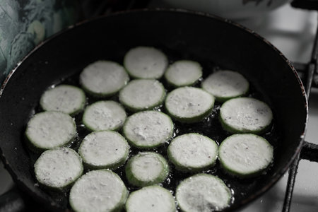 Zucchini are fried in oil in a skilletの写真素材