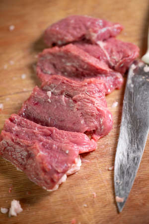 Meat and knife on a cutting boardの写真素材