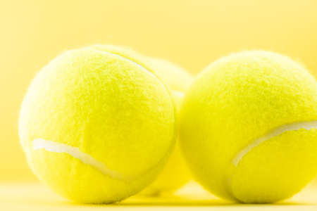 Tennis balls on yellow backgroundの写真素材