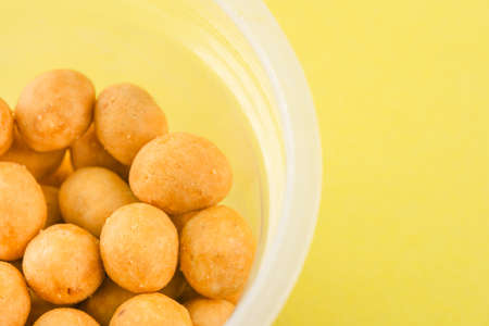 Peanuts in coconut glaze on yellow backgroundの写真素材