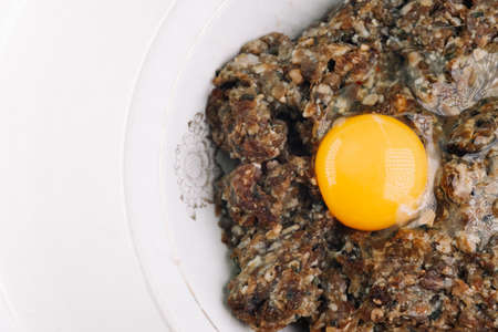 Egg and minced meat in a plate on a white backgroundの写真素材
