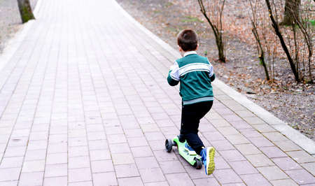 A child riding a scooter on the roadの写真素材
