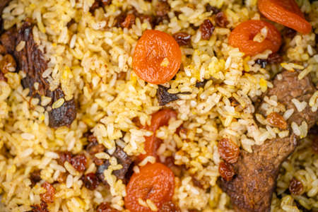 Pilaf with meat, dried apricots and raisins as backgroundの写真素材